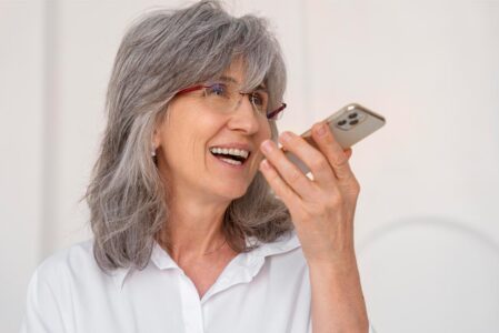 A photo of a woman holding a phone to contact us